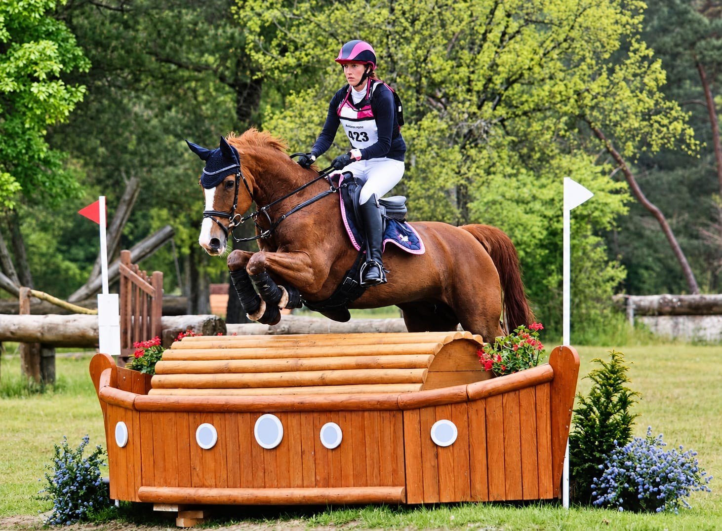 Kelly van Delft, préparatrice mentale du cavalier, en plein saut sur un obstacle de cross en concours complet