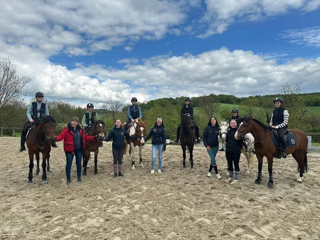 Cavaliers et chevaux réunis en carrière extérieure pendant un stage
